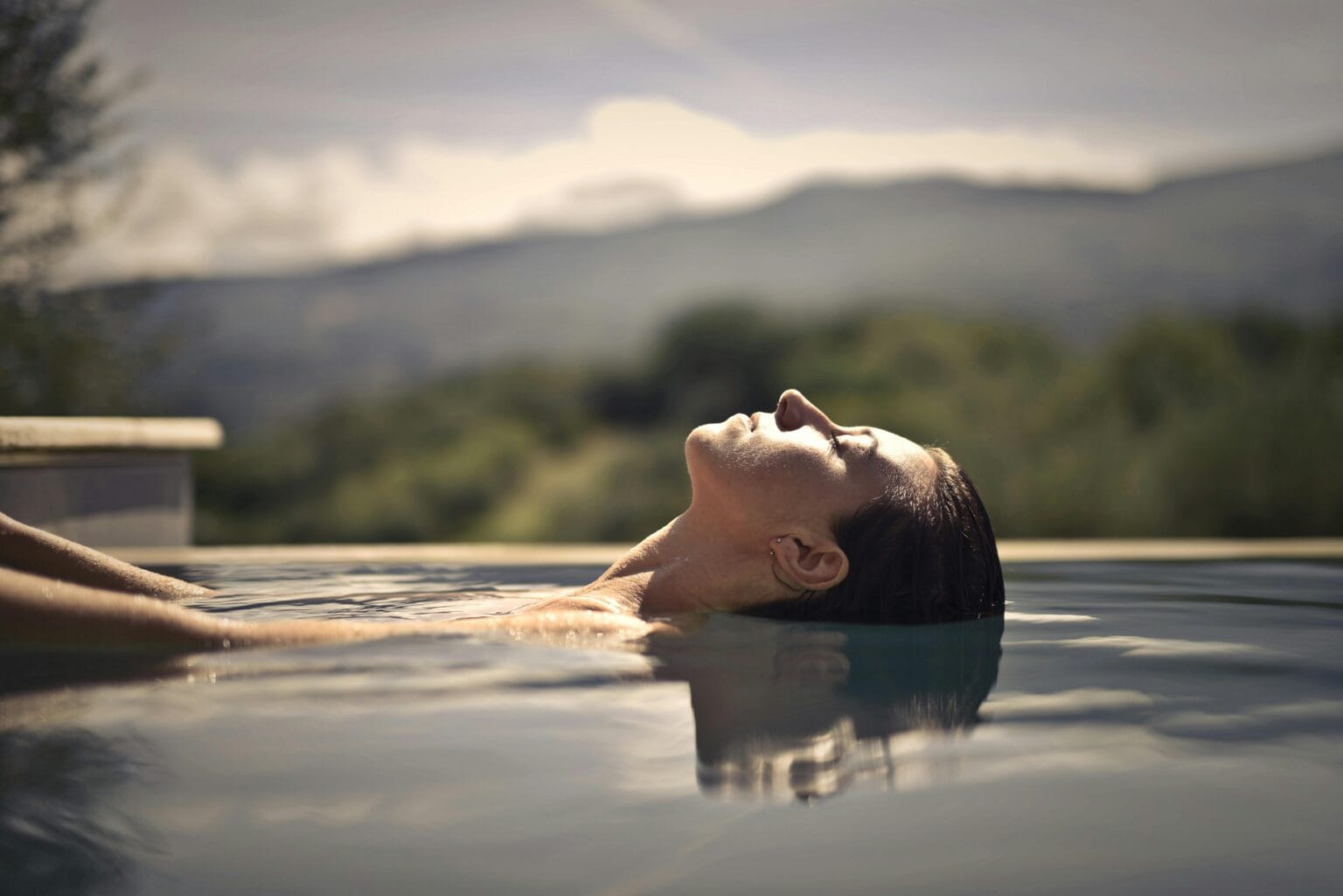 Personalized spa and wellness travel planning - a woman relaxing in a soothing spa pool