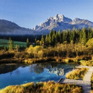 אגם הררי שקט עם השתקפות יער ושמיים כחולים ברורים.