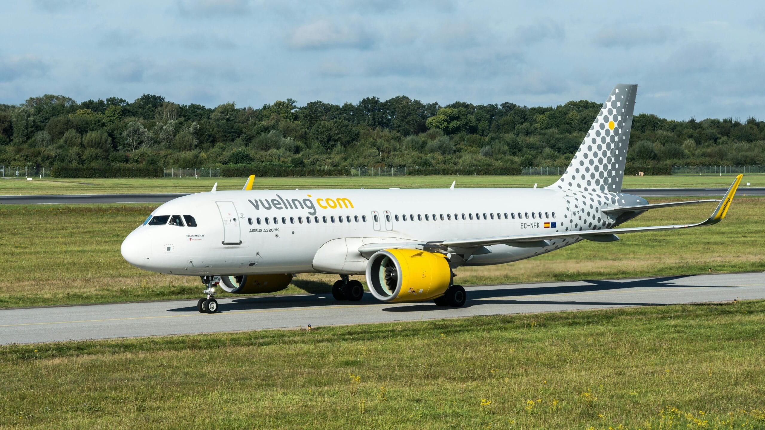 Shot of a Vueling Airbus A320 on a runway in Hamburg, capturing the essence of international travel.